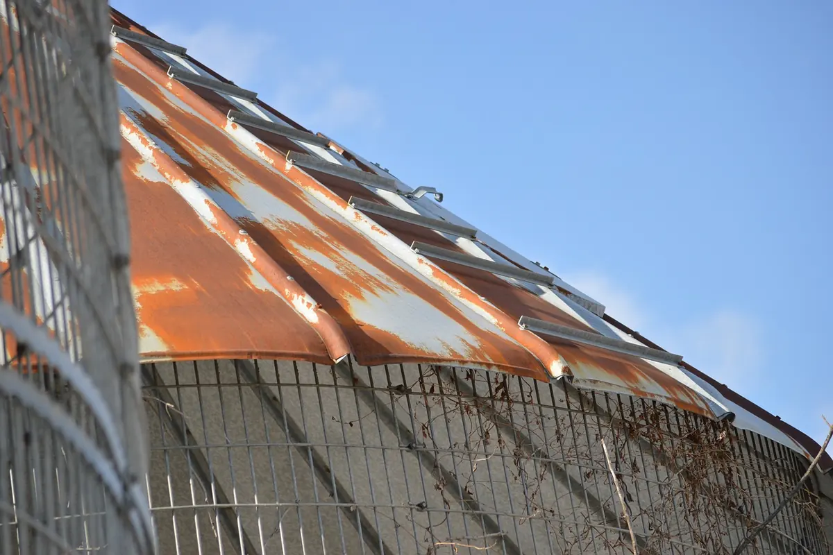 Vecchia copertura di capannone in lamiera arrugginita, da rifare